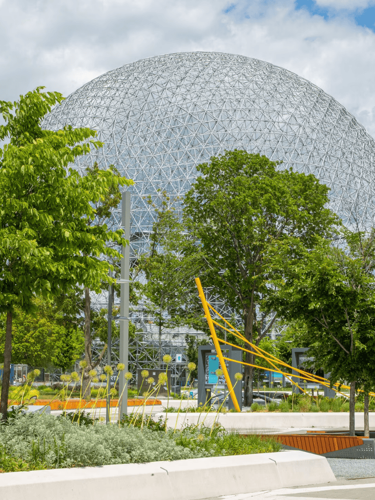 Futuristic geodesic dome with lush greenery and modern landscaping, showcasing innovative architecture in an urban park.