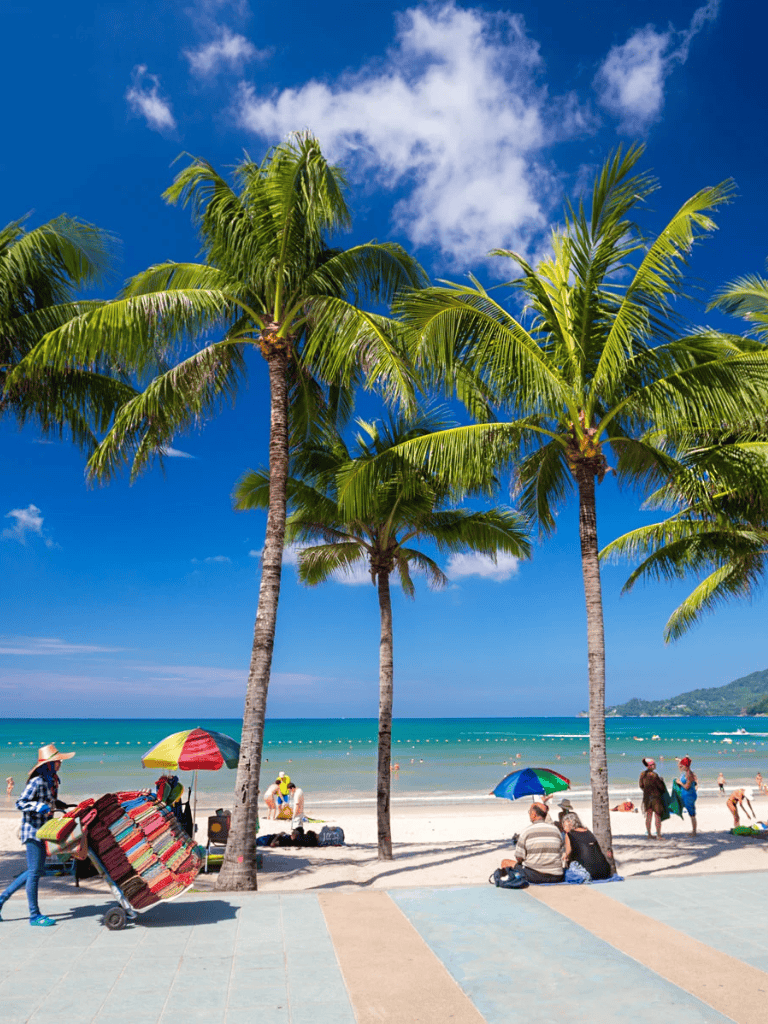 Palm trees on a sunny beach with beachgoers and umbrellas, tropical vacation at QuestForDirections.