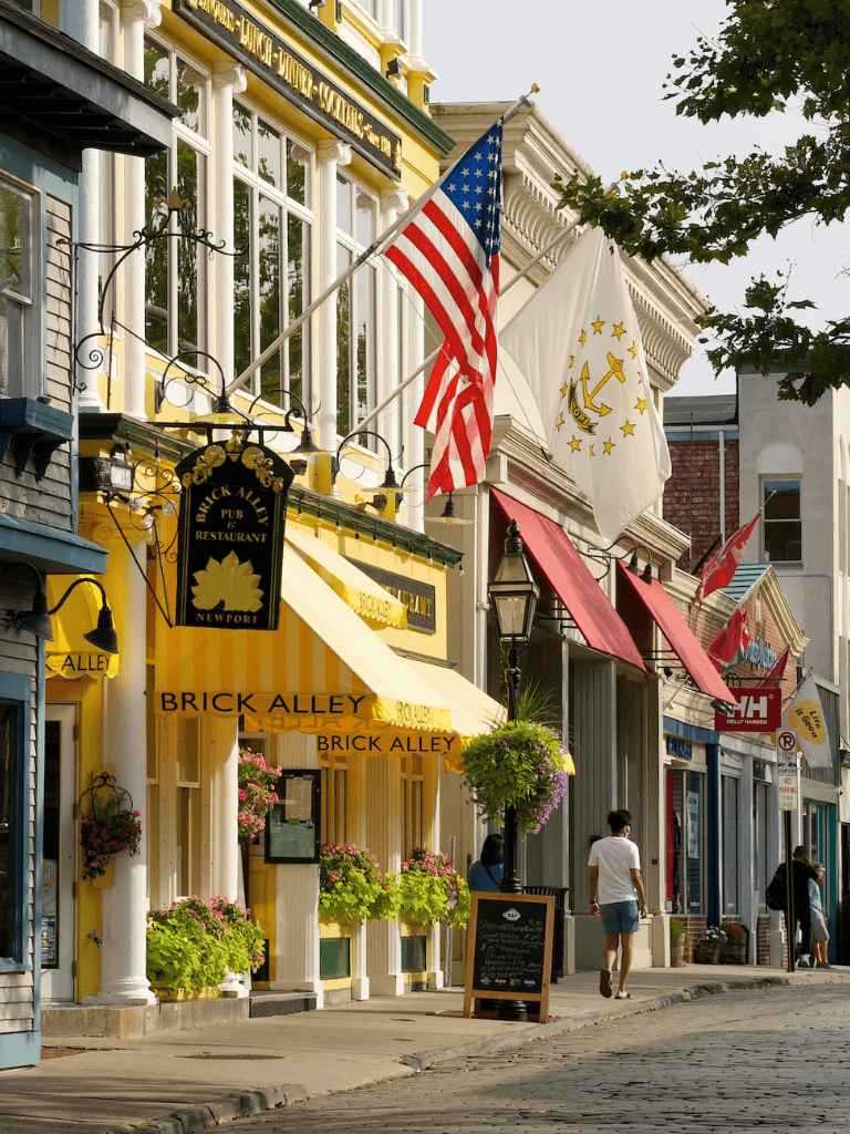 Flag American and Rhode Island, street view of Brick Alley Restaurant and shops in Newport, Rhode Island.