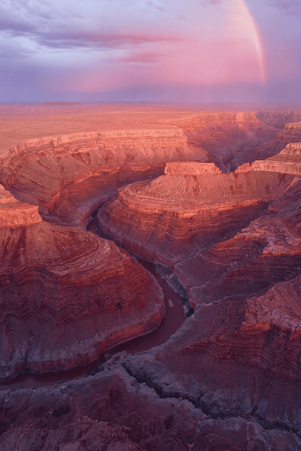 Vibrant view of the Grand Canyon at sunset with rainbow, highlighting Grand Canyon sightseeing and travel destinations.