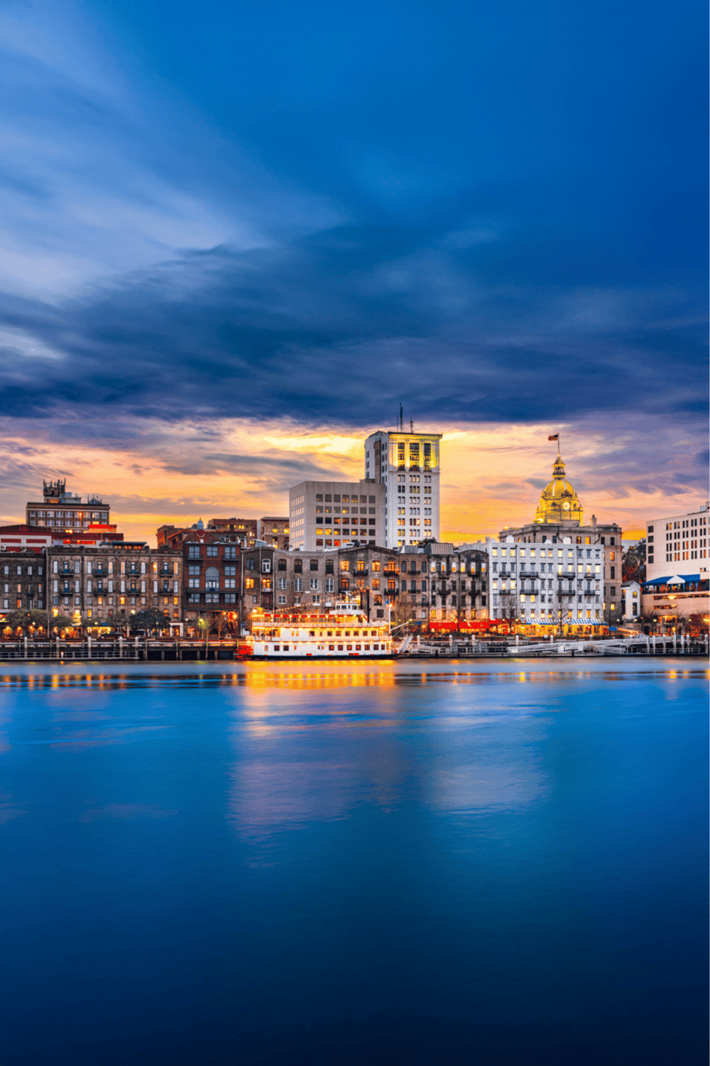 City skyline at sunset with waterfront, iconic buildings, and vibrant lights, showcasing urban navigation and travel destinations.