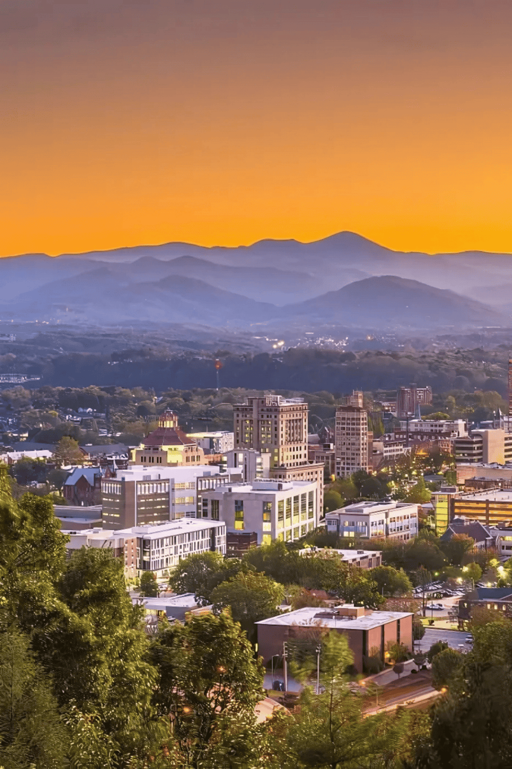Vibrant cityscape at sunset with mountains, featuring modern buildings and lush greenery, highlighting Quest For Directions' navigation services.