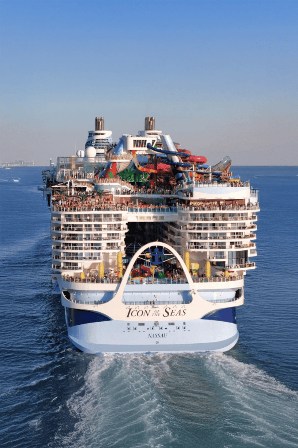 Luxurious cruise ship with water slides and pools, offering a tropical vacation experience.
