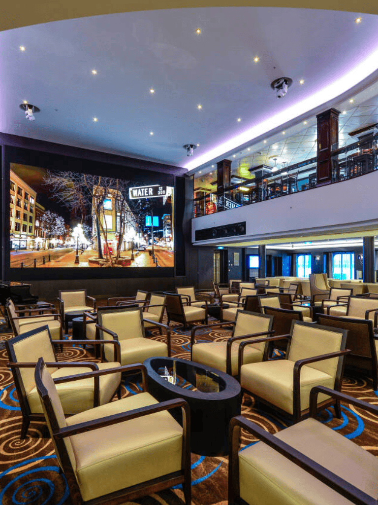 Bright indoor lounge at QuestForDirections with modern seating and large cityscape screen.