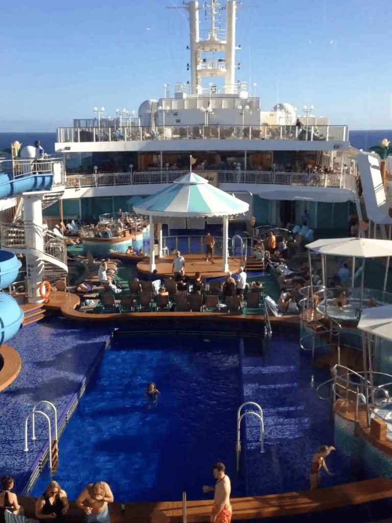 Cruise ship deck featuring pools, slides, and lounging areas for a luxurious vacation experience.