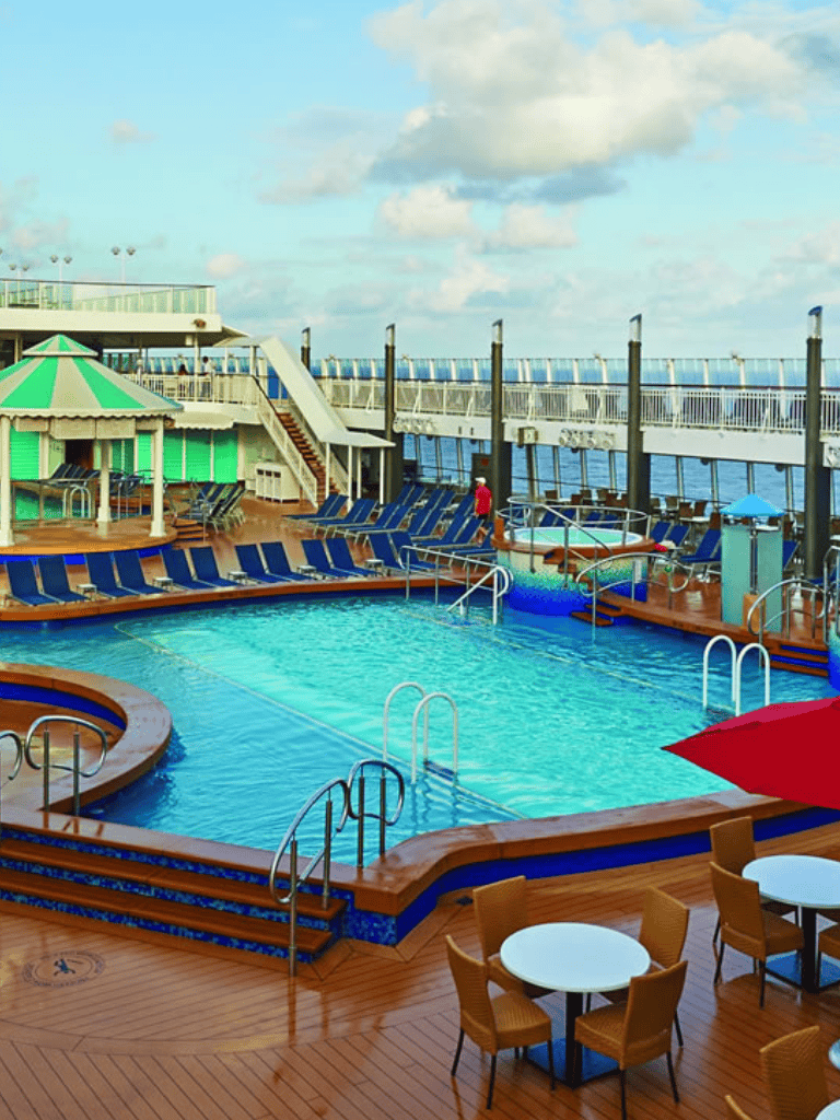 Relaxing cruise ship pool with lounge chairs and ocean views, perfect for onboard relaxation and entertainment.