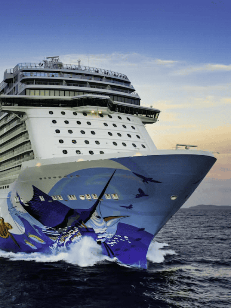 Luxury cruise ship sailing at sunset with vibrant blue ocean background.