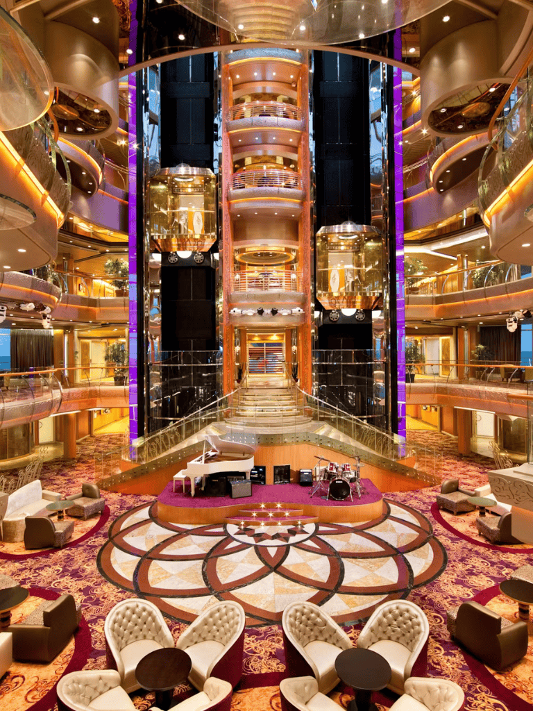 Elegant cruise ship atrium with luxurious decor and entertainment area.