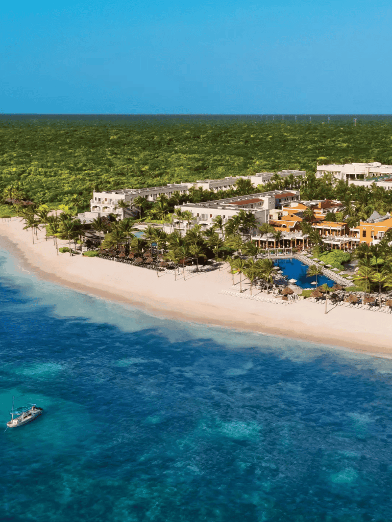 Beautiful beachfront resort with lush greenery and ocean views in Cancun, Mexico.
