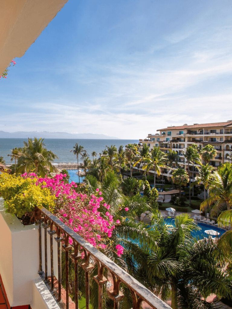 Spectacular ocean view from a hotel balcony with lush tropical greenery in Mexico.
