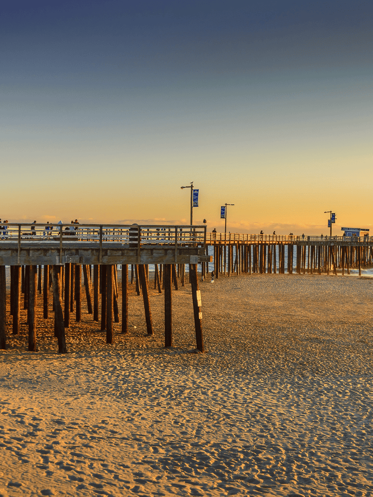 Scenic pier at sunset on the beach, perfect for coastal travel and outdoor adventures.