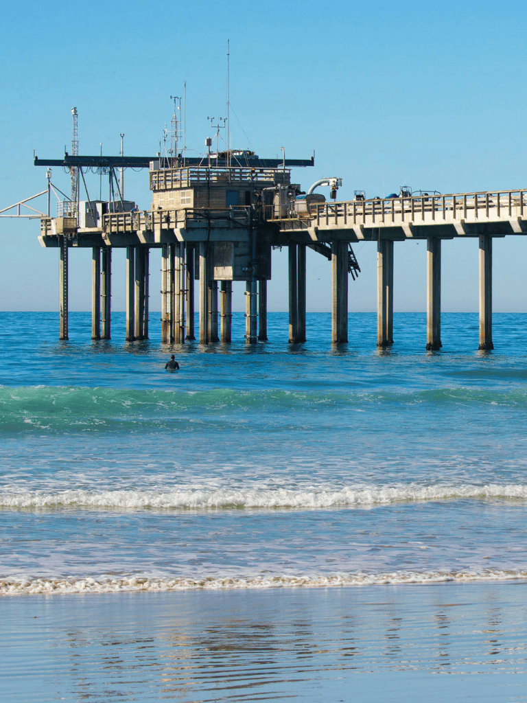 Seaside pier station with ocean view and clear blue sky.