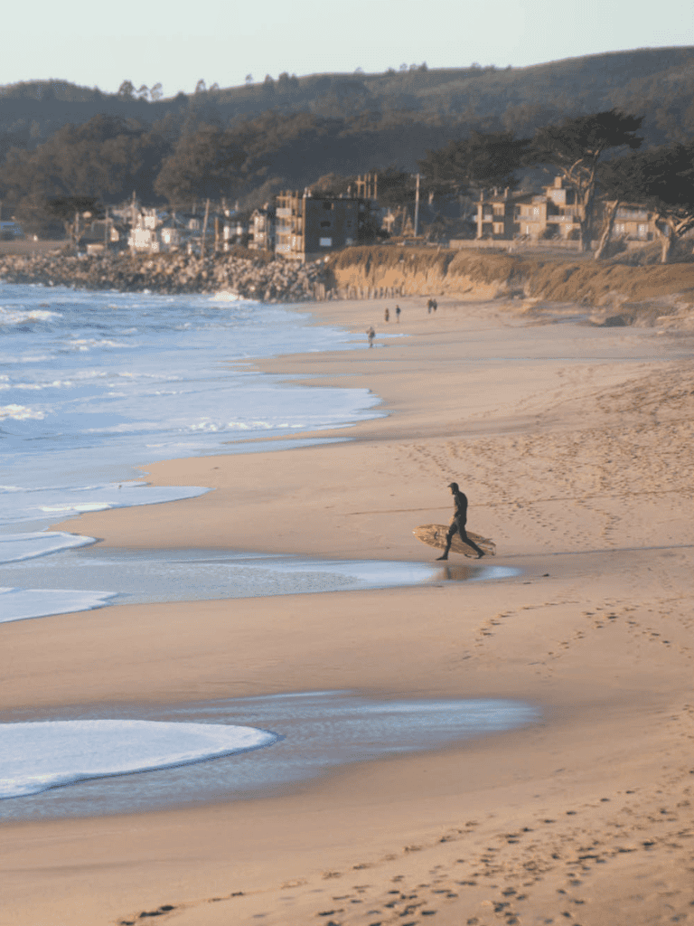 Serene beach with waves and footprints, scenic coastal view for travel and vacation photos.