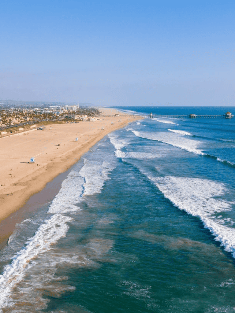 Sunset Beach coastline with ocean waves and pier, California ocean view, scenic beachscape.
