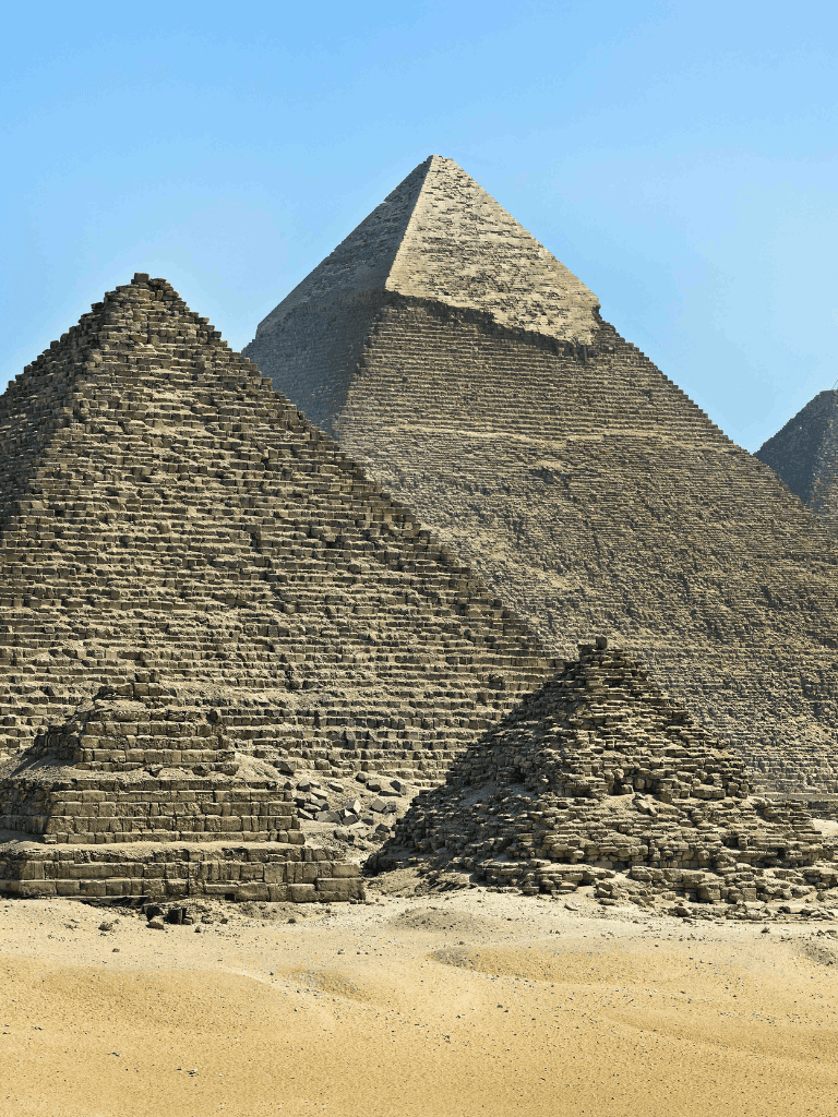 Ancient Egyptian pyramids in a desert landscape, historical travel destination, quest for directions pilgrimage site.