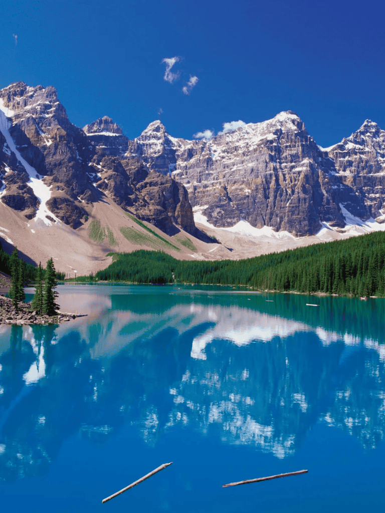 Serene mountain lake with snow-capped peaks and lush pine trees, perfect for outdoor adventures and nature exploration.