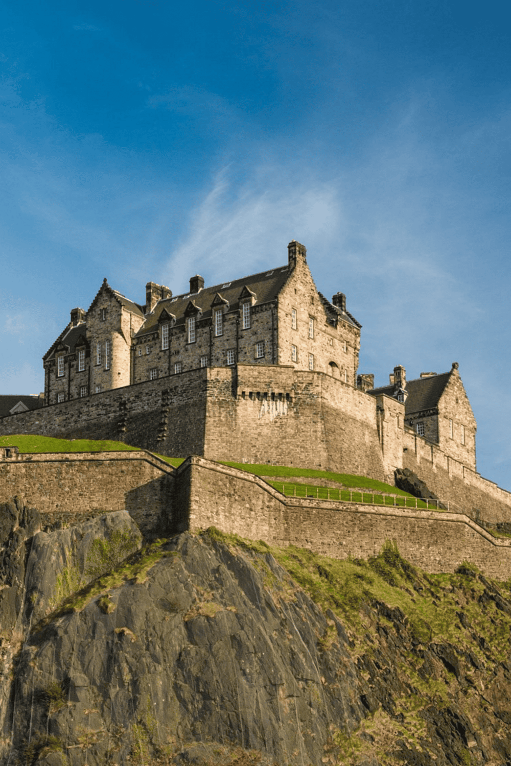 Majestic castle on a hill with clear blue sky, highlighting Scottish historic architecture.