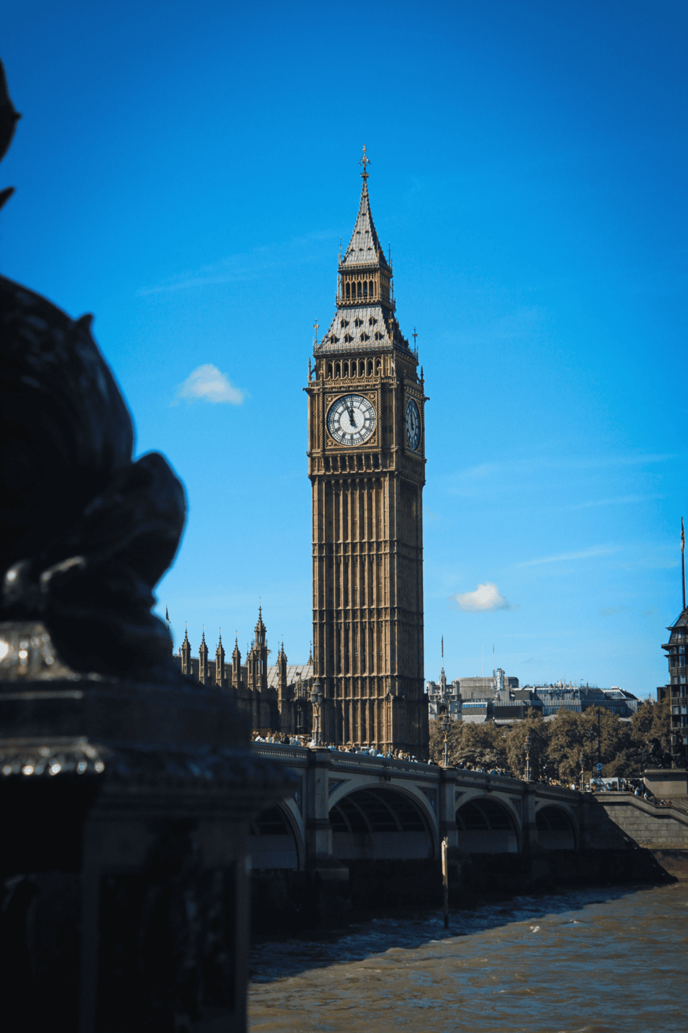 London Big Ben clock tower and the Houses of Parliament with clear blue sky, iconic UK landmark, popular tourist attraction.
