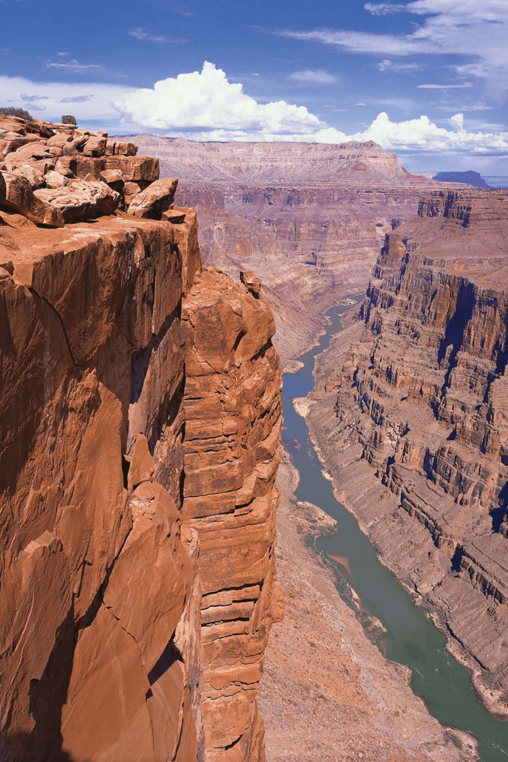Vast Grand Canyon landscape with river view, rugged cliffs, and dramatic sky, showcasing American national parks.