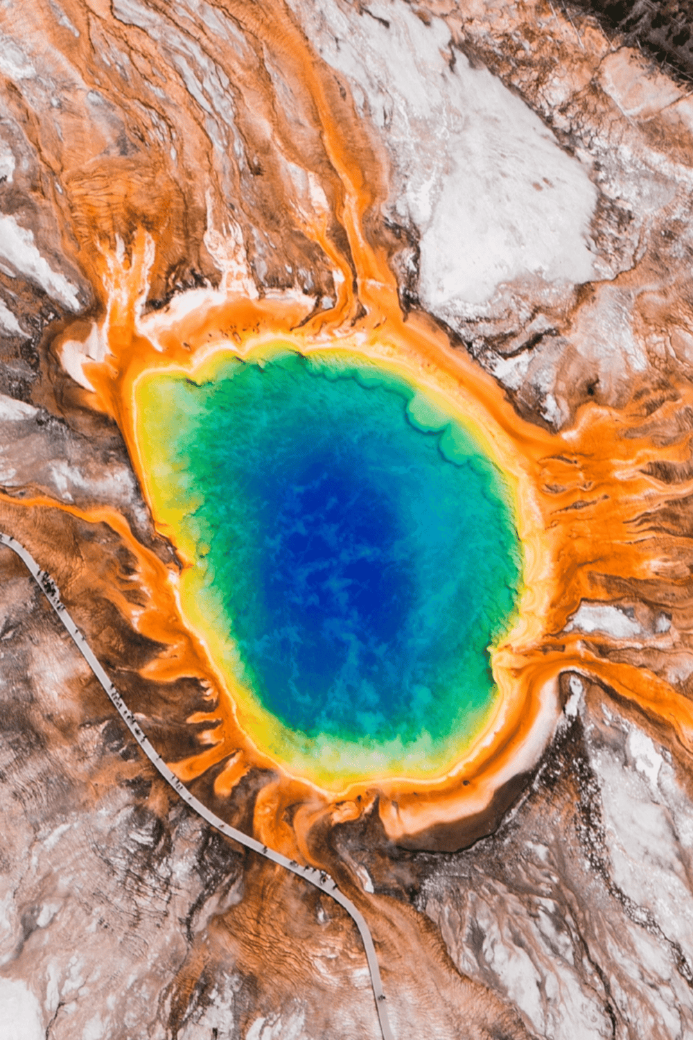 Vivid geothermal hot spring showcasing vibrant blue, green, and orange hues in a geothermal area.