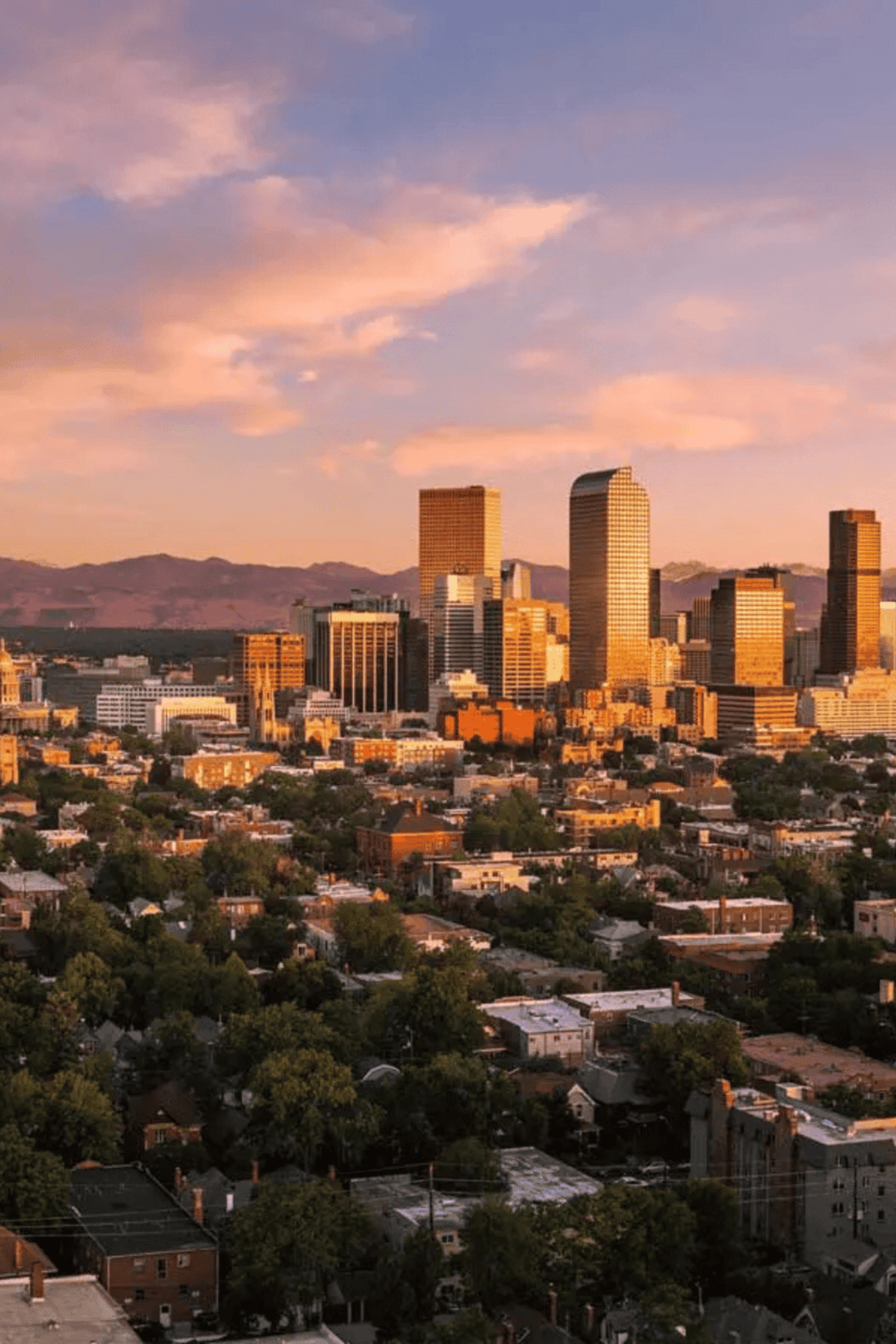 Downtown Los Angeles skyline at sunset, urban cityscape with tall skyscrapers and mountain background.