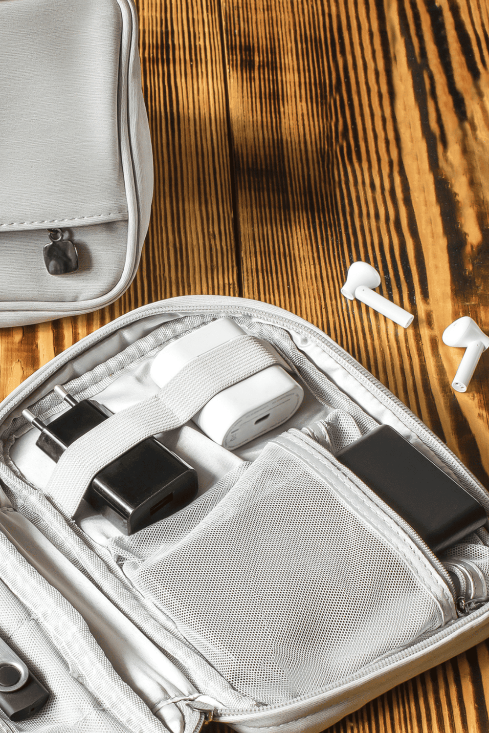 Wireless earbuds and electronic accessories in a travel backpack for convenient on-the-go entertainment.