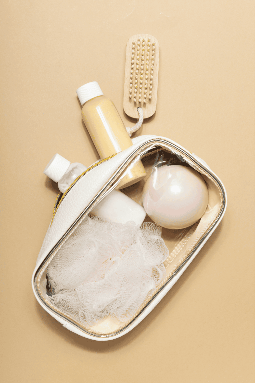 Travel toiletries kit with lotion, body wash, and shower puffs for travel essentials.