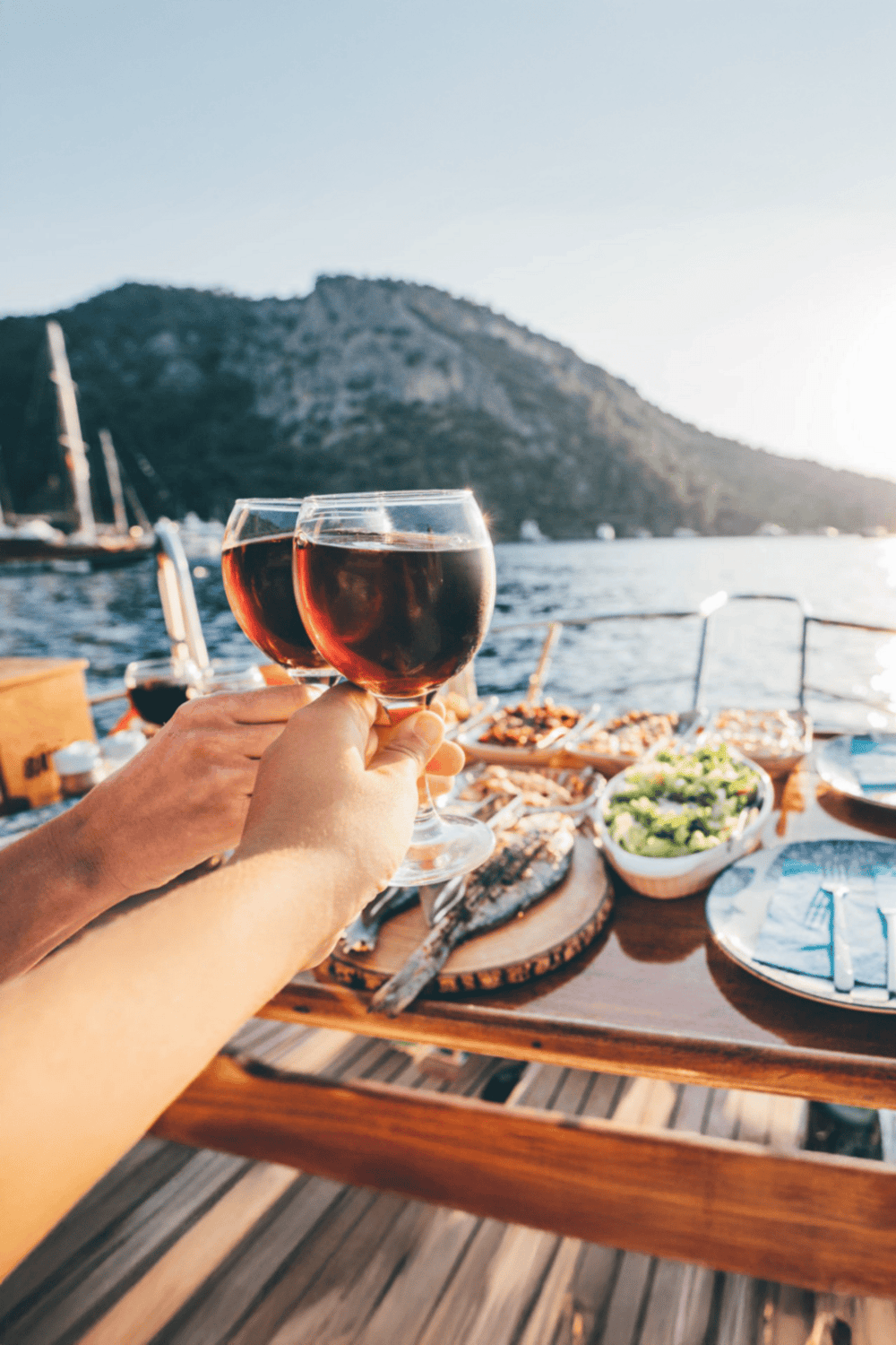 Relaxing waterfront dinner with wine, seafood, and scenic mountain views.