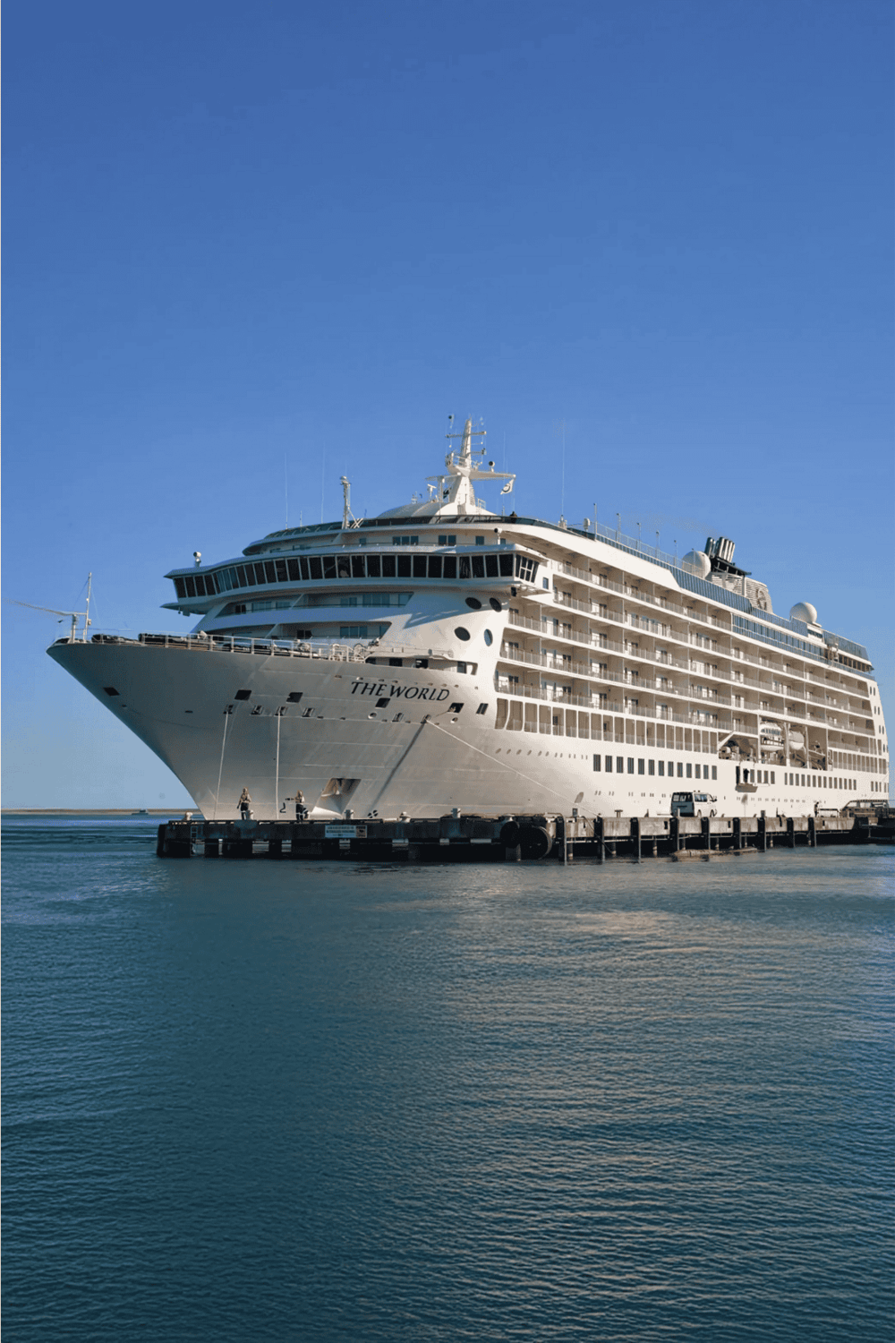 Luxury cruise ship docked at port with clear blue sky, perfect for memorable vacation cruises.