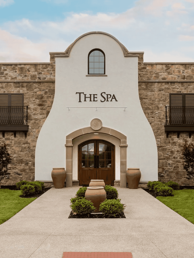 Elegant spa resort entrance with stone facade and lush landscaping for relaxation and wellness.