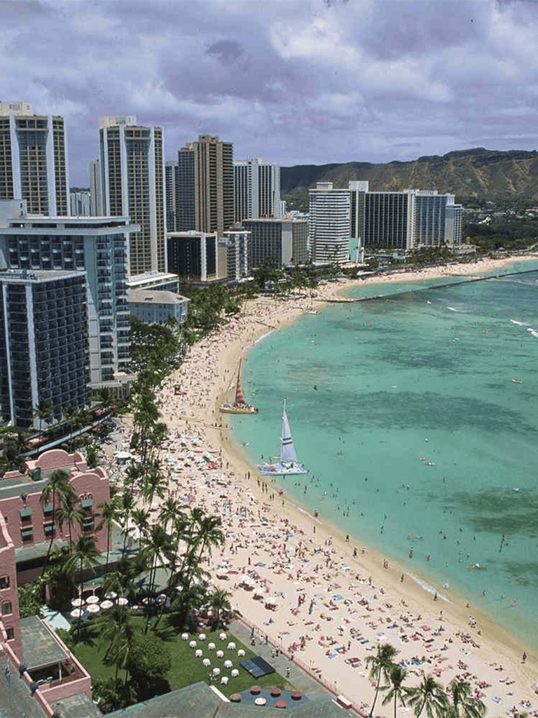 Stunning Waikiki Beach skyline with high-rise hotels and turquoise ocean waters.