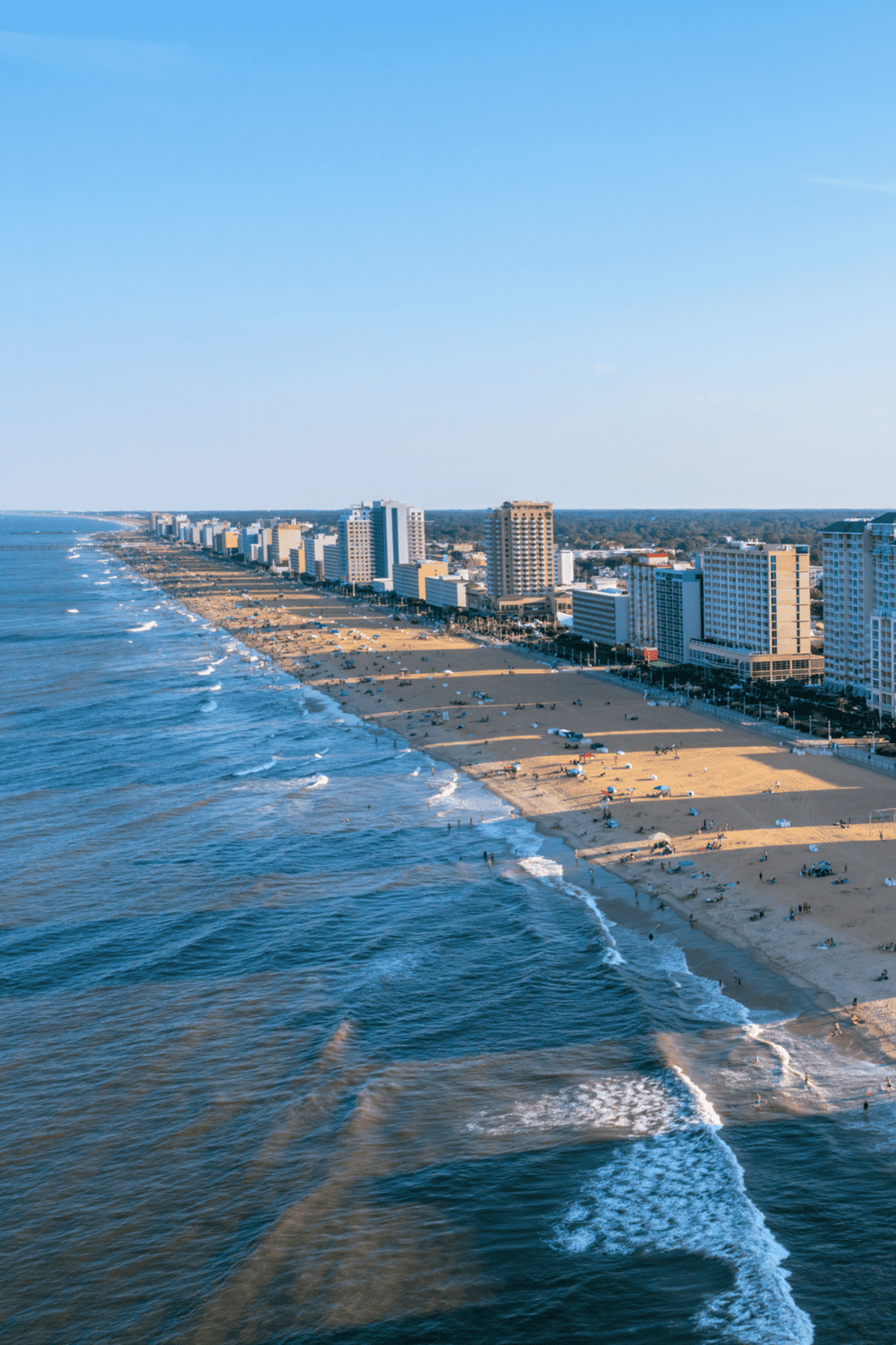 Beachside cityscape with ocean waves and high-rise buildings, showcasing coastal urban living.