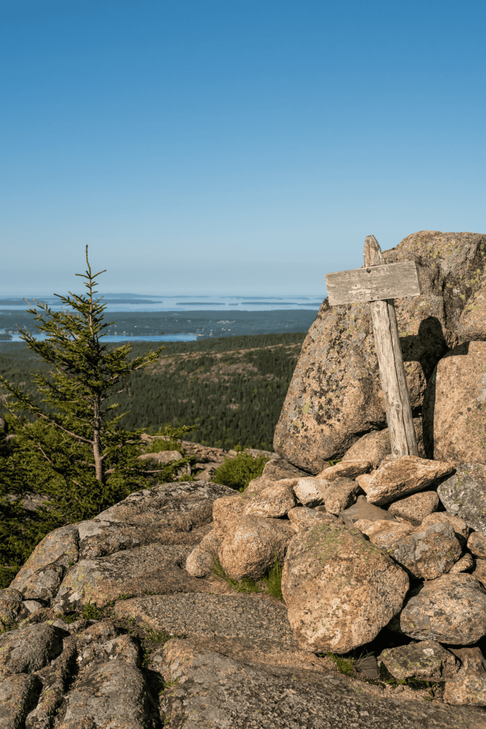 Guided mountain trail with scenic views and directional sign for outdoor adventure.