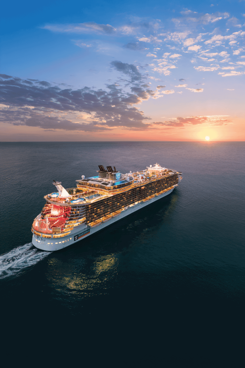 Luxury cruise ship sailing at sunset, offering ocean travel and vacation experiences.