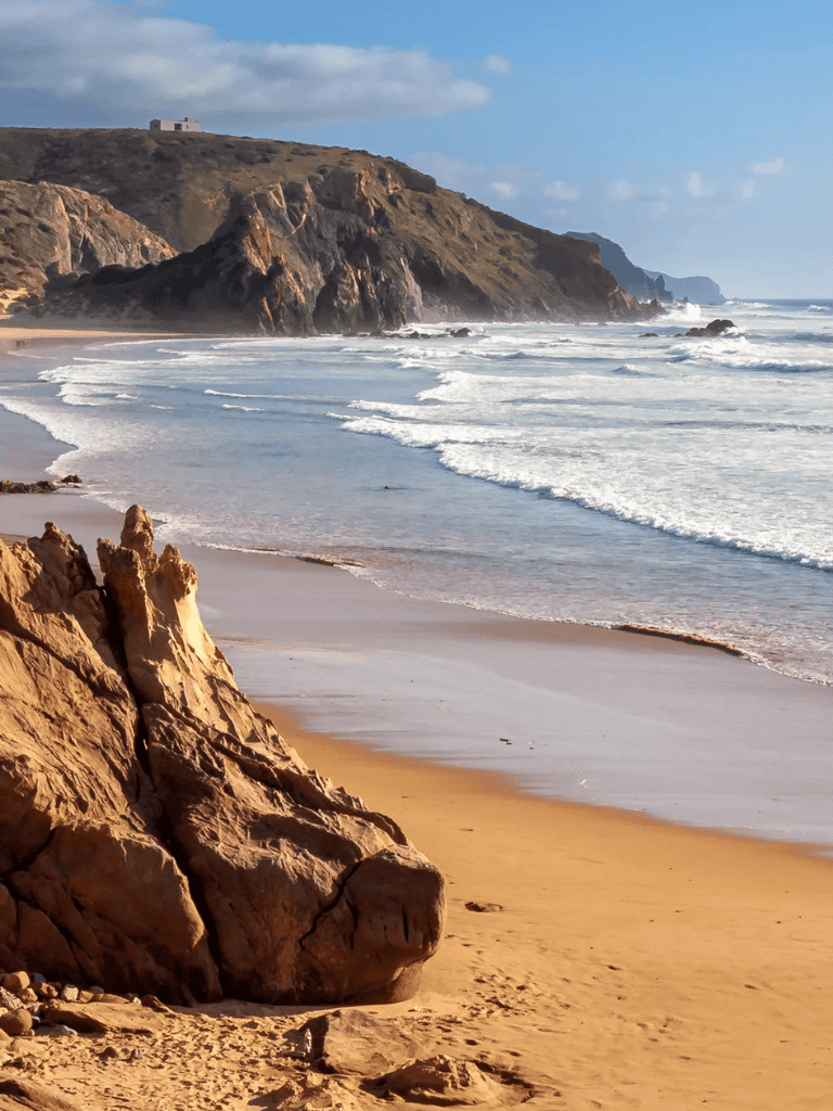 Serene beach with rocky cliffs and ocean waves, scenic coastal landscape in Southern California.