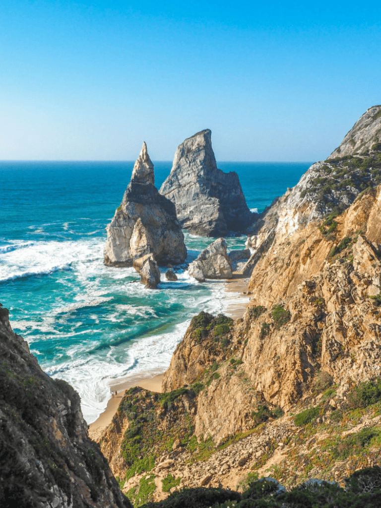 Spectacular coastal cliffs with towering rock formations along the ocean shoreline.