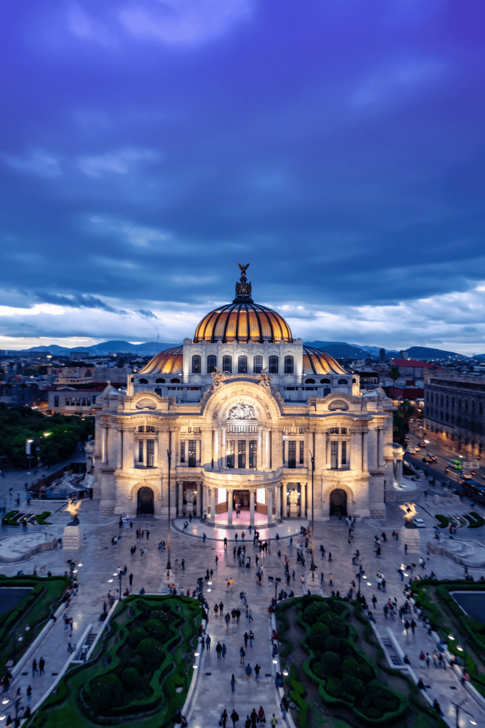 Elegant historic building with illuminated dome in Mexico City at dusk.