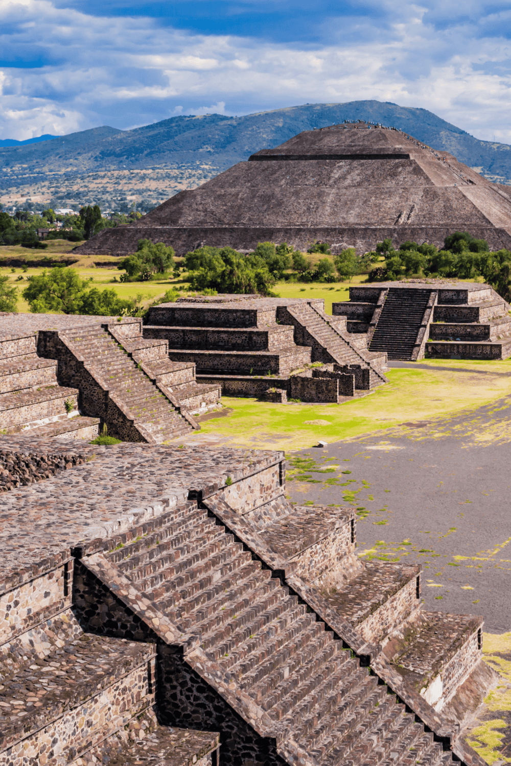 Ancient Mayan pyramid at Teotihuacan, Mexico, in a scenic landscape with vibrant sky.
