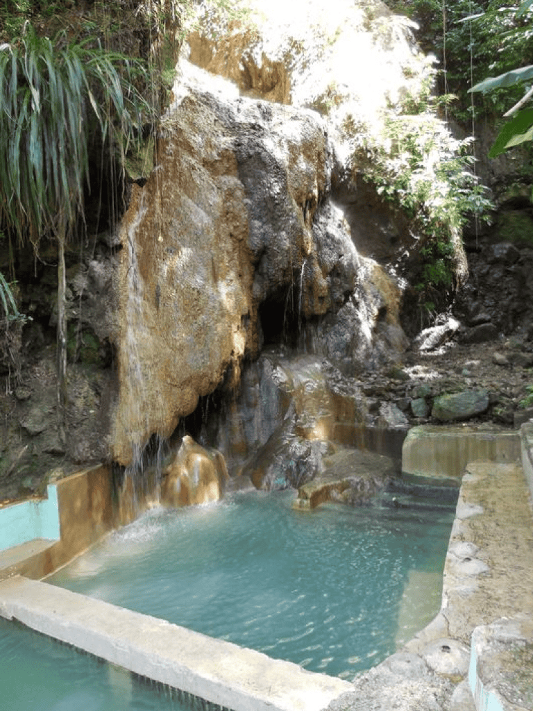 Natural waterfalls and pool at QuestForDirections, eco-friendly outdoor water oasis for relaxation.