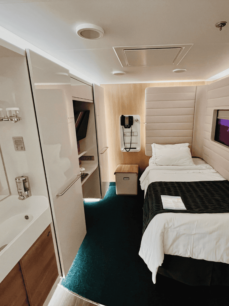 Bright hotel room with modern decor, comfortable bed, flat-screen TV, and workspace for travelers.