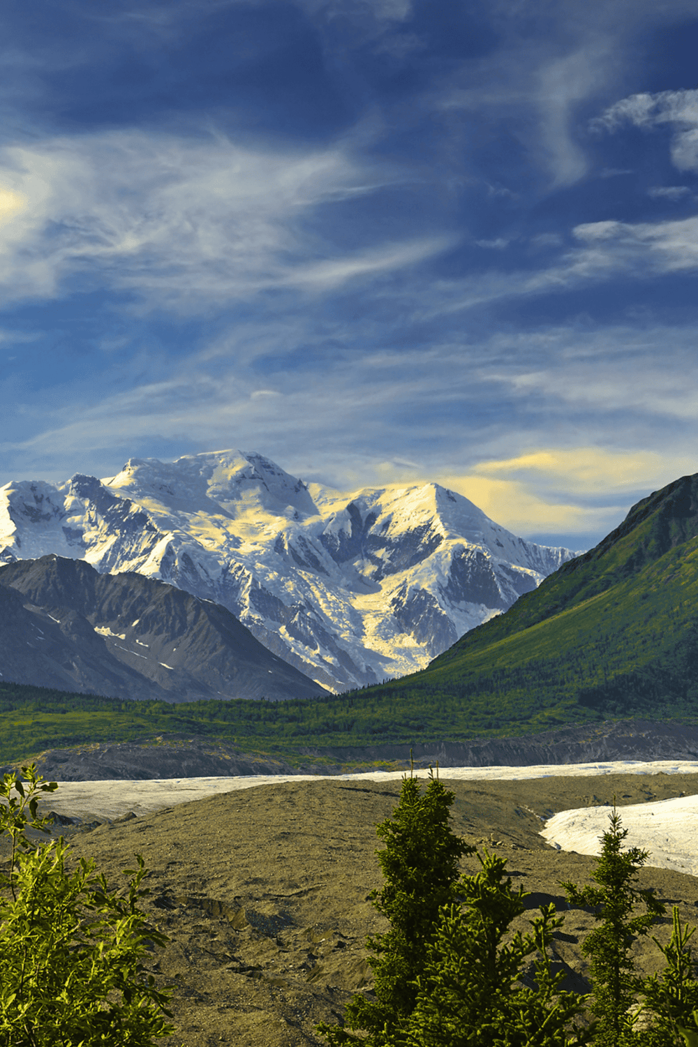 Snow-capped mountains with lush green valley, scenic Alaska wilderness, outdoor adventure destinations.