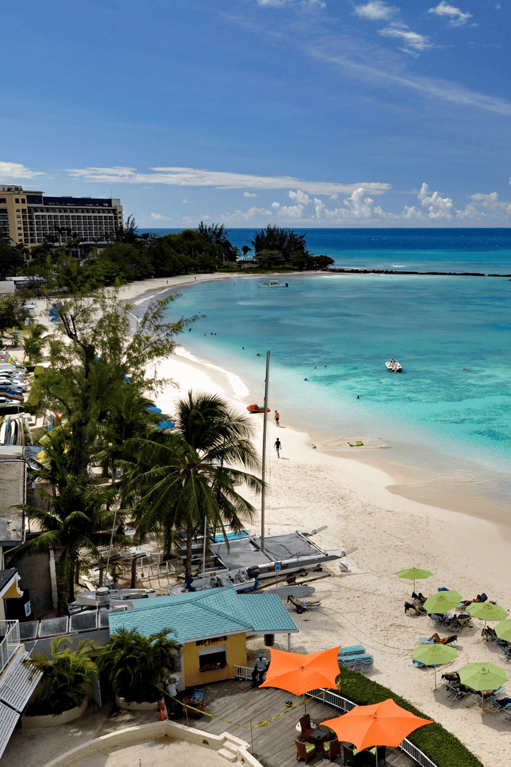 Bright tropical beach with clear turquoise waters and lush palm trees, perfect for vacation.