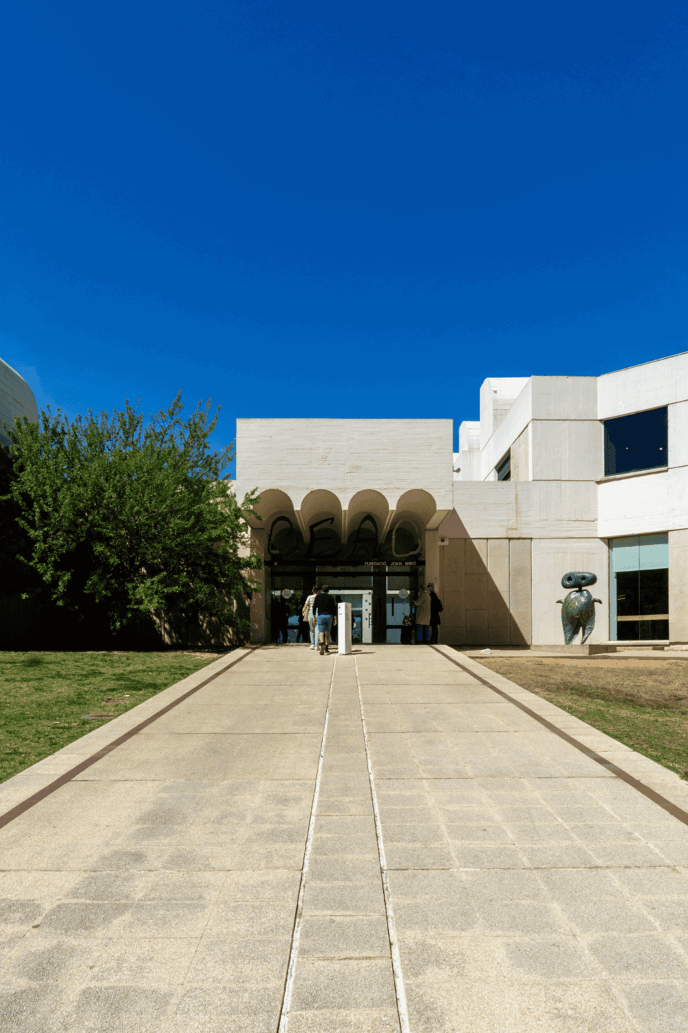 Modern art museum entrance with clear pathway and blue sky, highlighting innovative architecture and cultural experience.