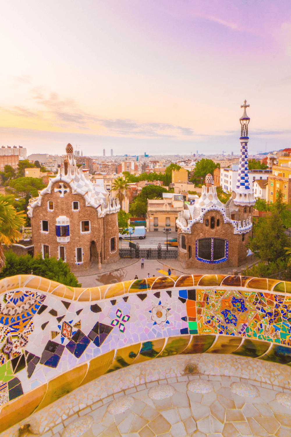 Colorful park in Barcelona, Spain, showcasing architectural style, vibrant mosaic tiles, unique buildings, and city skyline.