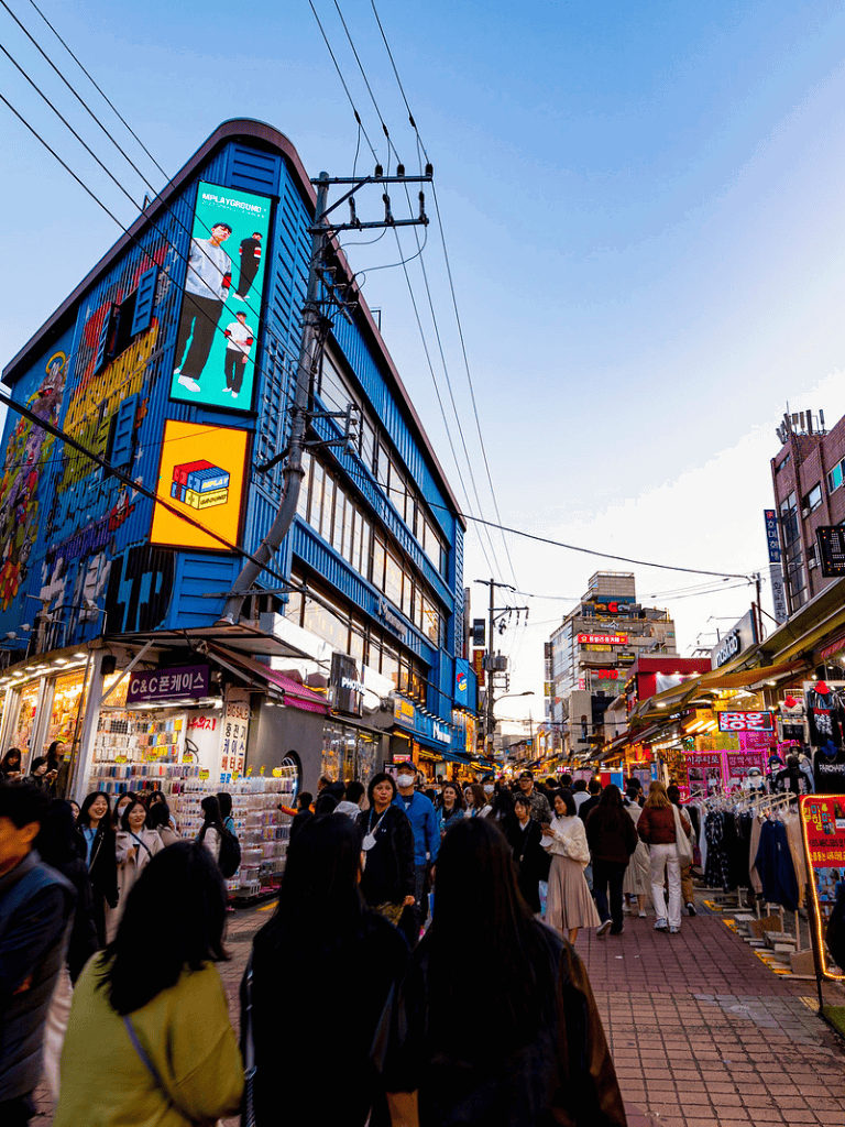 Vibrant street scene in Seoul with shopping stalls, urban architecture, and Passersby, capturing the lively atmosphere of QuestForDirections.