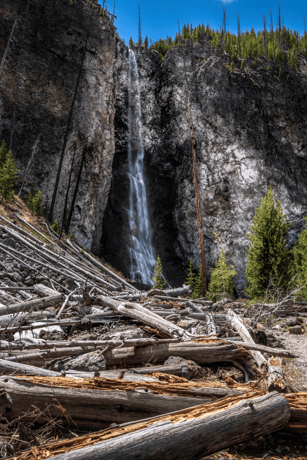1. Waterfall cascading down rocky cliff in forest landscape.