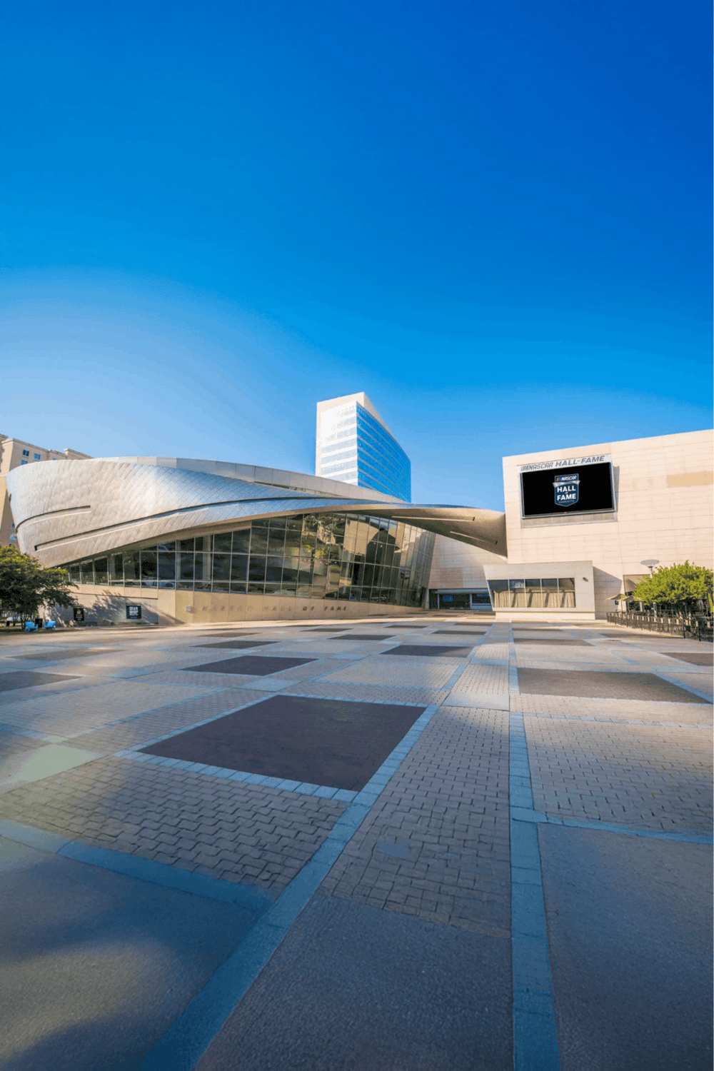 Modern sports arena with sleek architecture and NFL Hall of Fame signage, located in a vibrant city center.