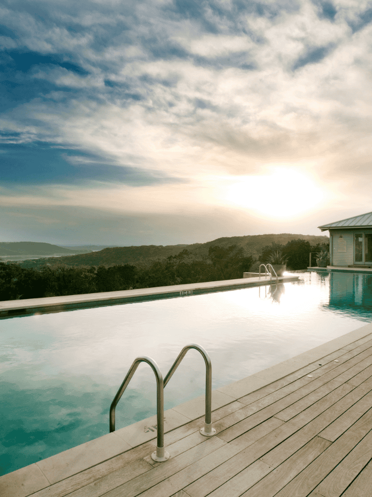 Relaxing outdoor swimming pool with scenic mountain view at sunset.
