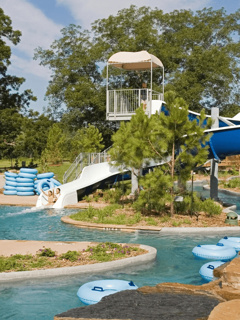 Water park with a blue slide and tube rides in a lush, green outdoor setting.