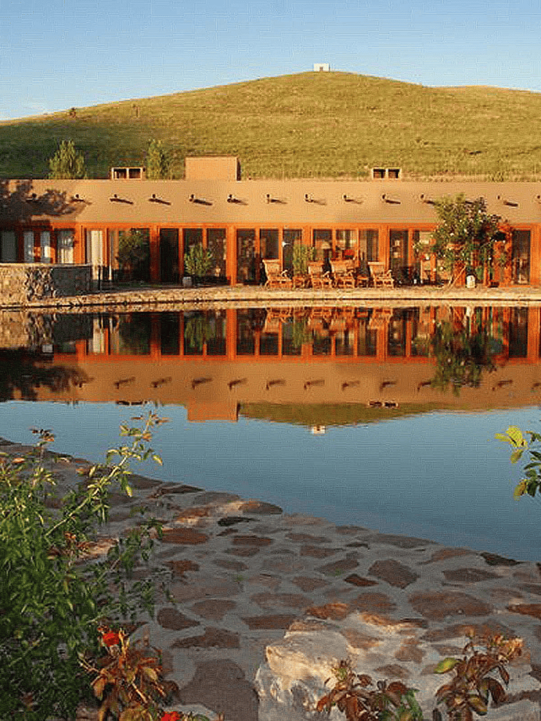 Serene lakeside lodge with outdoor seating and mountain view, ideal for nature retreats and travel planning.